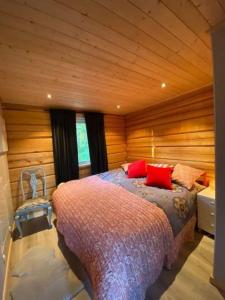 um quarto com uma cama e uma parede de madeira em UTSIKTEN -exklusivt nybyggt timmerhus -Plintsberg. em Tällberg