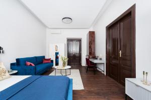 1 dormitorio con 1 cama azul y 1 sofá azul en Cracovian House by LoftAffair, en Cracovia