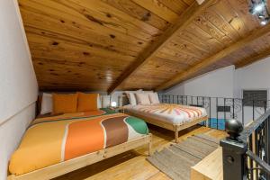two beds in a room with a wooden ceiling at The Self-Sustainable Beach House in South Padre Island +43 photos