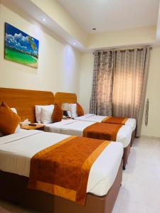 um quarto de hotel com três camas num quarto em Marhaba Deira Hotel em Dubai