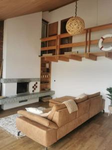 a living room with a couch and a fireplace at NEB-THUN Seehaus Einigen in Einigen