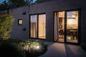 a house with large glass doors and a dining room at De verloren hoek in Aarschot