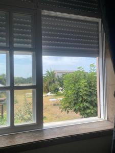 uma janela com vista para um jardim em Garden Hostel em Aradas