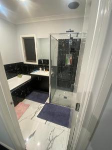 een badkamer met een glazen douche en 2 wastafels bij Private room in shared house in Wollert