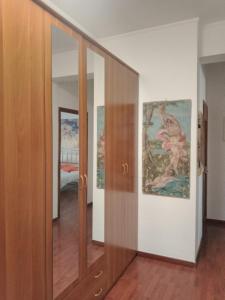 un couloir avec une porte coulissante et une peinture sur le mur dans l'établissement I Rifugi di Noah 1 Santa Maria a Vico-, à Santa Maria a Vico