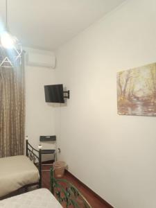 Cette chambre comprend un lit et une télévision murale. dans l'établissement I Rifugi di Noah 1 Santa Maria a Vico-, à Santa Maria a Vico