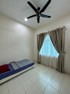 a bedroom with a ceiling fan and a window at RumahKu Homestay, Taman Jasin Perdana in Jasin
