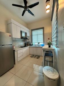 a kitchen with a ceiling fan and a refrigerator at RumahKu Homestay, Taman Jasin Perdana in Jasin