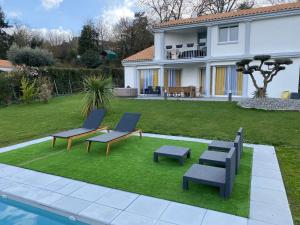 a yard with two chairs and a pool and a house at Parker et Tammy in Saint-Gelais