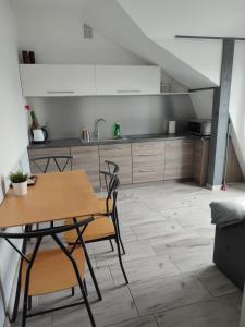 a kitchen with a table and chairs in a room at Apartamenty Bulwar Nadmorski, Rowy in Rowy