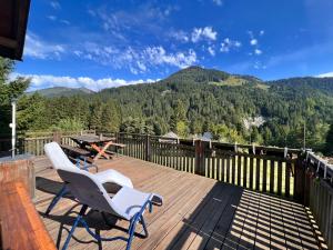 a deck with two chairs and a table and mountains at Haus Susi in Dornbirn