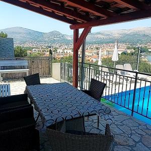 a patio with a table and chairs and a pool at Apartmani Balan s vanjskim bazenom in Trogir