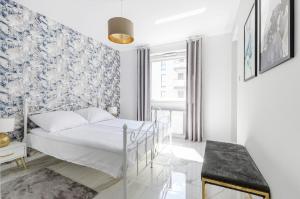 1 dormitorio con cama y papel pintado azul y blanco en Lumina luxury apartments Manufactura, en Łódź