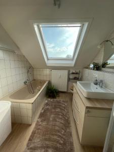 baño con lavabo, bañera y ventana en Schöne Wohnung, Bodenseenähe, en Ravensburg
