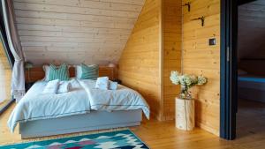 1 dormitorio con 1 cama en una pared de madera en Osada Miód Malina, en Istebna