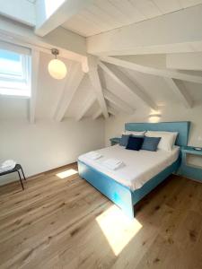 ein Schlafzimmer mit einem blauen Bett im Dachgeschoss in der Unterkunft NAVETTA in Rapallo