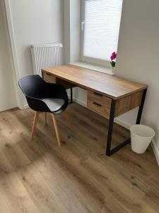een bureau met een zwarte stoel en een houten tafel bij Wohlfühl-Oase in Herne