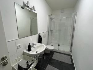 een witte badkamer met een wastafel en een douche bij Wohlfühl-Oase in Herne