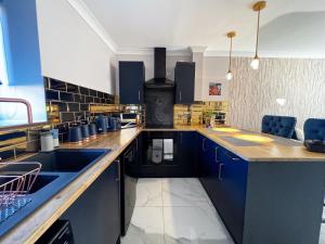 a large kitchen with blue cabinets and a sink at Lock View Cottage in Boston