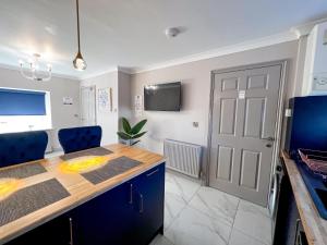 a kitchen with a table and blue chairs and a door at Lock View Cottage in Boston