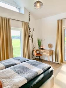 a bedroom with a bed and a desk and a window at Freistehendes Ferienhaus direkt an der Nordsee mit Sauna und Pool! 10 Personen in Sehestedt