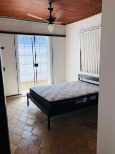 uma cama num quarto com uma ventoinha de tecto em Casa na Enseada- Guaruja no Guarujá