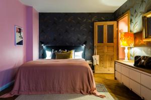 a bedroom with a bed and a purple wall at Brilliant Apartments in Berlin