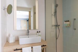 a bathroom with a sink and a shower at Hampton by Hilton Tours Centre, France in Tours