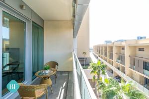a balcony with a table and chairs on a building at Stylish 1 Bedroom In Al Raha Beach in Abu Dhabi