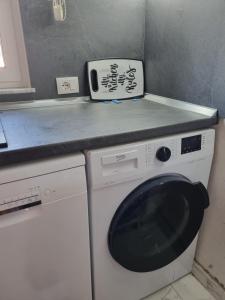 a washing machine in a kitchen with a counter at Titi's home Velipoje in Velipojë