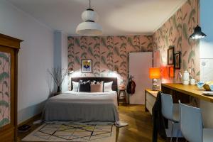 a bedroom with a bed and a desk with chairs at Brilliant Apartments in Berlin