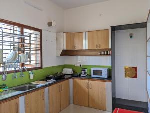 a kitchen with wooden cabinets and a sink at Athreyas@60/A in Mysore