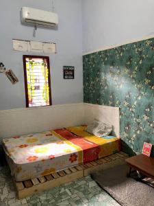 a bed sitting in a room with a window at Ohana Homestay Banyuwangi in Banyuwangi