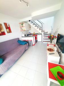 a bedroom with a bed and a kitchen and stairs at BungaLove Maspalomas in Maspalomas