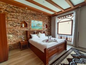 um quarto com uma cama e uma parede de tijolos em Durrat Nizwa Hotel em Nizwa
