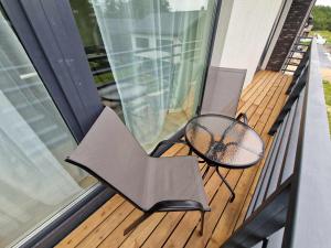 a porch with two chairs and a table on a balcony at 4rest in Palanga