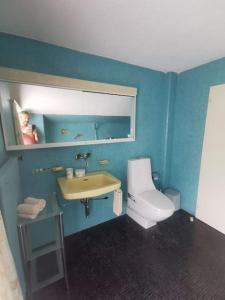 a blue bathroom with a toilet and a sink at NEB-Thun Haus in Thun für 8 Pax in Thun