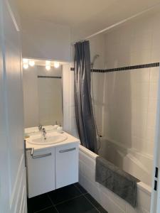 a white bathroom with a sink and a shower at Vivez en appartement en centre-ville - Hotel de ville - 1 ch in Le Havre