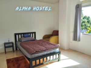a small bed in a room with a couch at ALPHA Hostel Cafe&Bar in Ban Khlong Yai