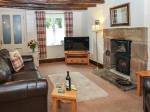 a living room with a couch and a fireplace at Candlelight Cottage in Buxton