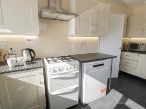 a kitchen with a stove and a white refrigerator at Trem Y Foel in Penrhyndeudreath