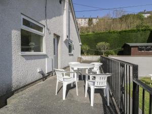 a table and chairs on the balcony of a house at Trem Y Foel in Penrhyndeudreath