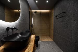 a bathroom with a black tub and a shower at Sogni D' Oro in Zakynthos