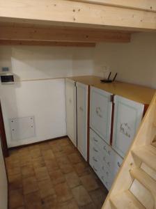 uma cozinha com armários brancos e uma bancada em Ladinische Jagerhof - Solaria CIPAT: 022113-AT-013003 em Campestrin