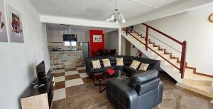 a living room with a couch and a staircase at Spacious Three Bedroom Apartment in Grand Gaube