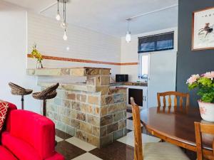 a living room with a table and a brick fireplace at Spacious Three Bedroom Apartment in Grand Gaube