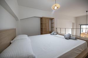 a white bedroom with two beds and a window at Sogni D' Oro in Zakynthos