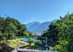 a garden with a swimming pool and mountains in the background at Falgerhof in Vollan