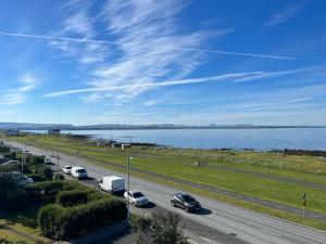a highway with cars parked on it next to the water at Luxury Apartment In Prime Location Ocean View in Reykjavík