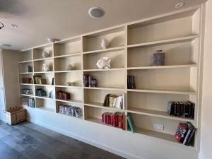 a book shelf in a room with books at White House Lodges in Heveningham